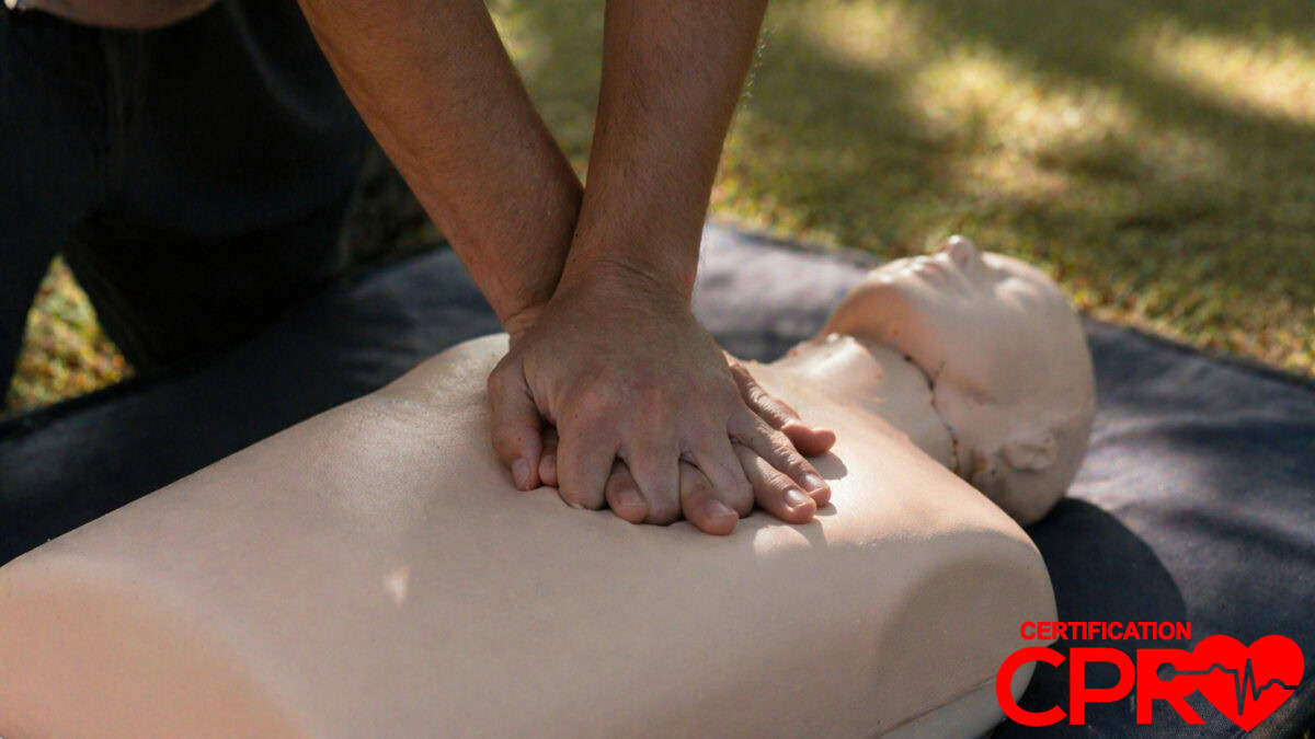 Person performing hands-only CPR on a mannequin outdoors in El Paso.